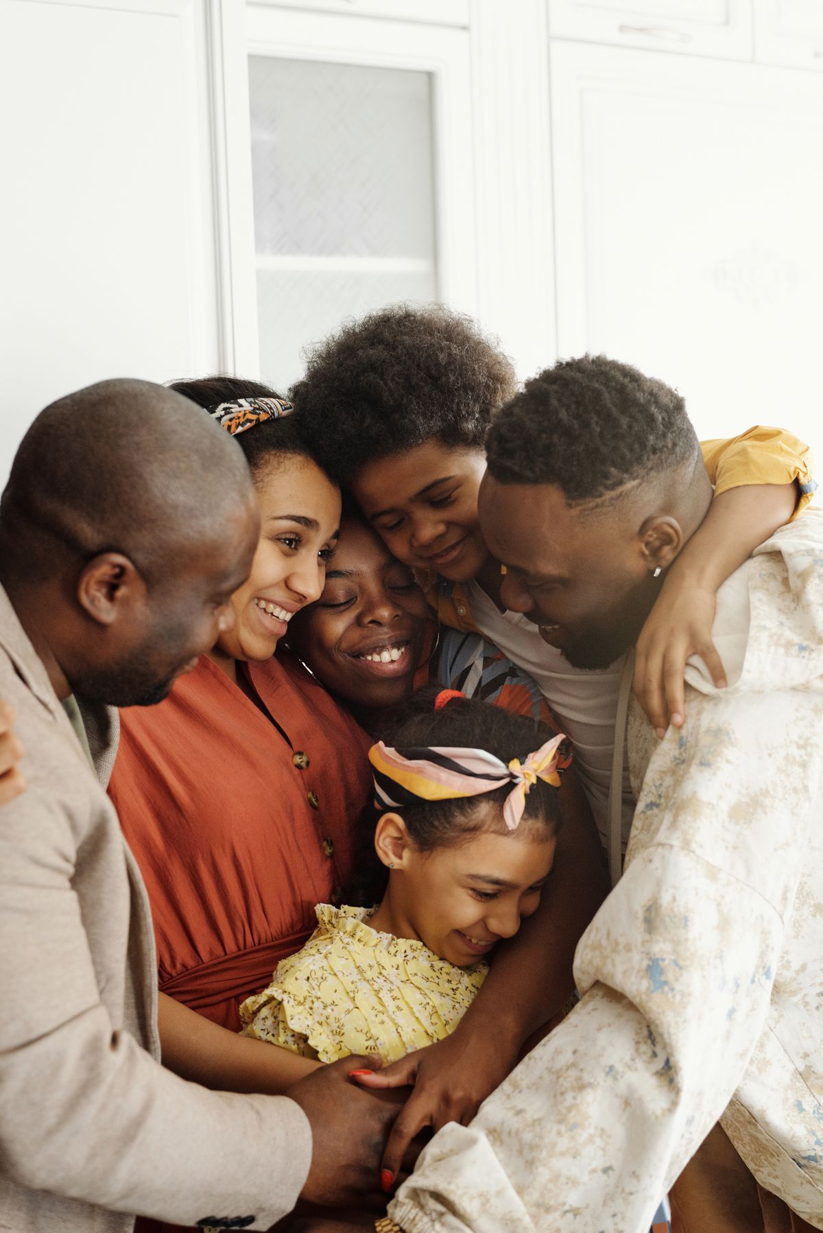 Família reunida em um abraço coletivo, sorrindo